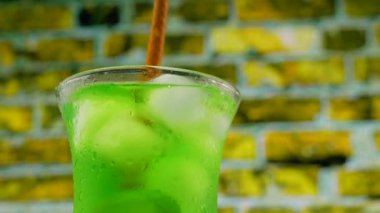 Tezgahın üzerinde yeşil limonata var. Buzlu soğuk kokteyl. Şeffaf bardakta yeşil limonata.