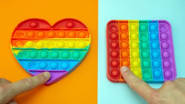 Stres önleyici. Popüler bir stres giderici oyuncak. LGBT kalp bayrağı. Parmağını silikon oyuncak antistrese bastırıyorsun. Patlat.