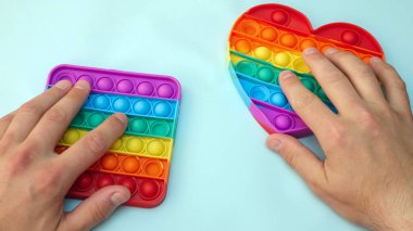 Stres önleyici. Popüler bir stres giderici oyuncak. LGBT kalp bayrağı. Parmağını silikon oyuncak antistrese bastırıyorsun. Patlat.