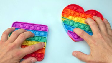 Stres önleyici. Popüler bir stres giderici oyuncak. LGBT kalp bayrağı. Parmağını silikon oyuncak antistrese bastırıyorsun. Patlat.