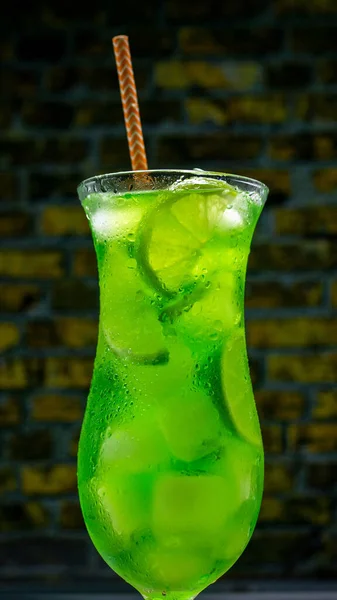 Alkoholický Koktejl Sklenici Cihlovém Pozadí Vertikální Obrázek Zelená Limonáda Ledem — Stock fotografie