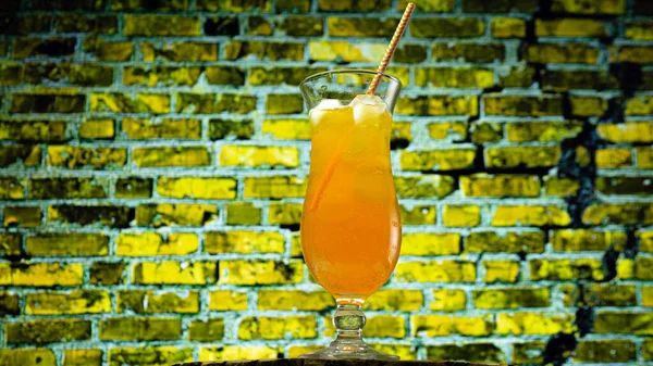 Oranje Cocktail Met Een Rietje Een Gele Bakstenen Muurachtergrond Koeldrankje — Stockfoto