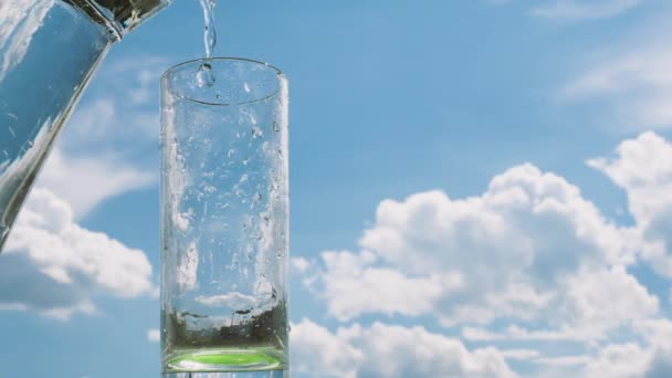 Versare Acqua Bicchiere Trasparente Sullo Sfondo Del Cielo Belle Nuvole — Video Stock