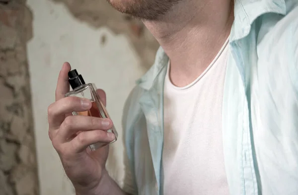 Men perfume in the hands of a man
