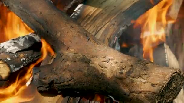 一根木头着火了 特写背景美丽的柴火熊熊燃烧 用橙色的火焰慢慢地把劈开的木头烧在石头壁炉里 — 图库视频影像