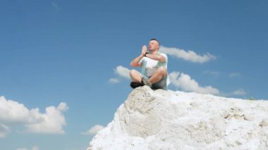 Bir adam dağda meditasyon yapar, yoga yapar, dua eder. Atletik adam