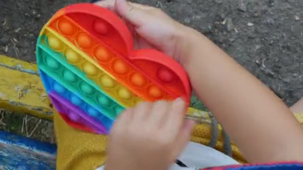 Uma Criança Pequena Joga Jogo Pop Pressionando Espinhas Com Dedos — Vídeo de Stock