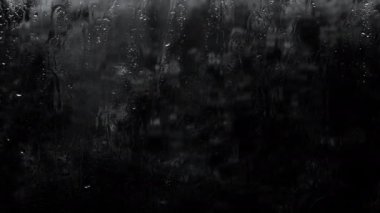 Yumuşak odak Yağmuru siyah arka planda, bardaktan aşağı süzülen su damlaları karanlıkta. Parayı bırak.