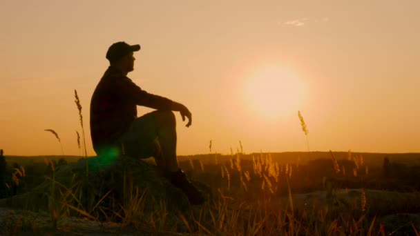 日落时分 一个忧思 梦想的人坐在一座山上 这个人正在欣赏山顶上的落日 — 图库视频影像
