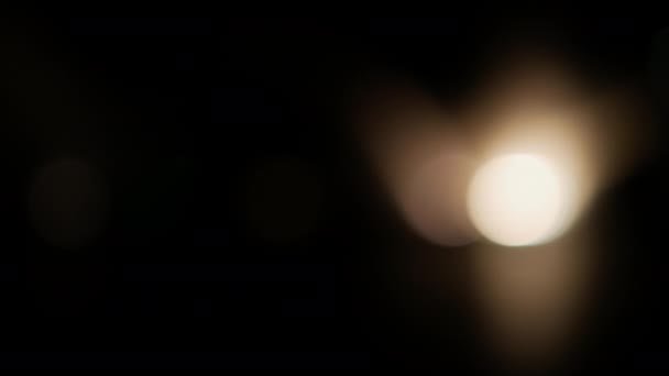 黑色背景上的Bokeh黄色镜头照明弹 闪烁的灯泡 光的效果 黑暗中的聚光灯 — 图库视频影像