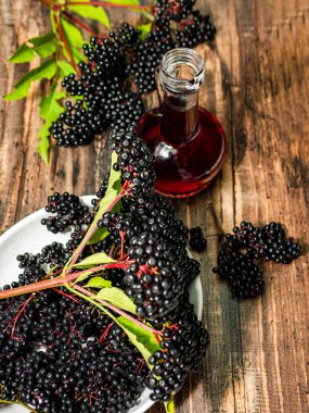 Şişe içinde Mürver böğürtlen, tabakta olgun böğürtlen, sıkılmış mürver suyu. Kırmızı çay şifalıdır..