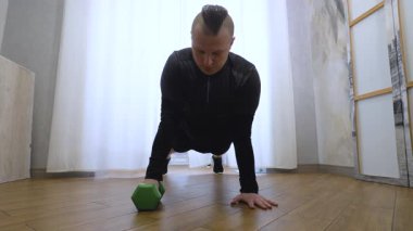 Kol eğitiminde dambıllar yatar pozisyonda. Evde erkek antrenmanı. Yavaş çekim