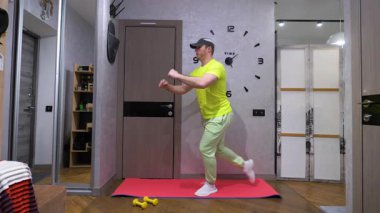 Paspasın üzerinde spor eğitimi. Hamle egzersizinde basını salla. Dizini bükerek bacağını kaldırıyor. Yavaş çekim.