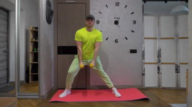 Dambıl egzersiziyle çömelme egzersizi. Evde erkekler için fitness eğitimi. Yavaş çekim