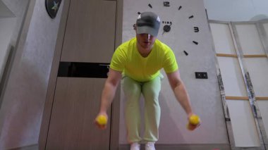 Ellerinde dambıllar, omuzlarında omuz ve kollar, dambıllarla yanan yağlar, dambılı olan genç adam eğitimi..