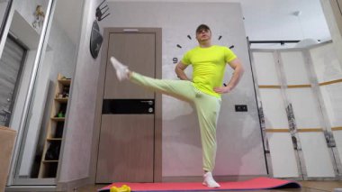 Fitness paspasında bacak sallıyor. Batman bacağı. Evde idman yapıyorum. Yavaş çekim