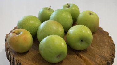  Sulu yeşil elmalar yuvarlak bir masada döner. Yavaş çekim.