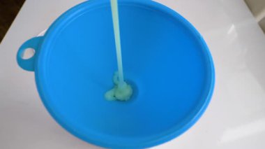 Sıvı sabun plastik sulama kutusundan kavanoza dökülür. Sıvı yeşil. Boya akıyor. Yavaş çekim