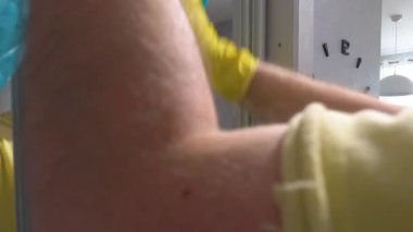 Aynaya deterjan sıkıyorum. Müzik kulaklıklı bir adam evde kirli bir ayna yıkıyor. Daire temizliği, yaşam tarzı. Ağır çekim. Yakın plan..