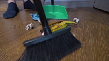 Süpürgeyle faraş süpürüyorum, yakın plan. Dairenin katındaki kirleri temizleyen adam, ağır çekimde..