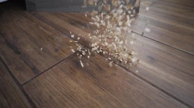 Bir tabak yemek fayanslı mutfak zeminine düşer. Yulaf ezmesi yavaş çekimde yere dökülür. Çöp yere düşer.