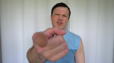 Bir adam kendisine gelen jestler gösterir, bir adam birini arar, sonra elleriyle yüz ifadelerini gösterir ve gösterir. Beyaz arka planda, yavaş çekim