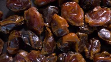 Kuru tarihler, yakın çekim makro çekim, üst görüş. Pikapta, hareket halinde dönüyor. Yavaş çekim