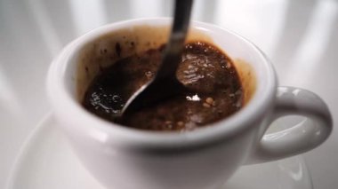 Hazır kahveyi kaşıkla fincanda karıştır. Granüllerde hazır kahve, ağır çekimde. Kahve fincanda sade içecek. Yakın plan.