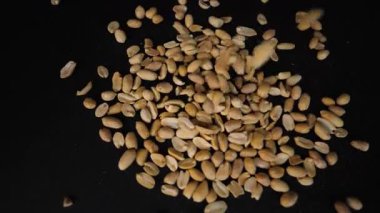 Kabuklu fıstıklar yavaş çekimde döner tablaya düşüyorlar..