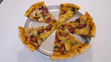 Pizzayı bir tabakta yakın çekimde döner döner, ağır çekimde..