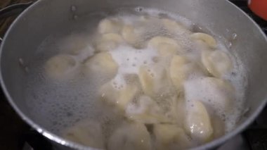 Tencerede hamur köftesi pişirmek. Mutfakta yemek pişirmek. Yakın plan..