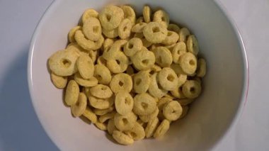 Müsli tabakta yüzükler, üst manzara, tabakta kahvaltı yemeği, yavaş çekimde döner döner döner döner döner döner döner tabakta. Yakın plan..