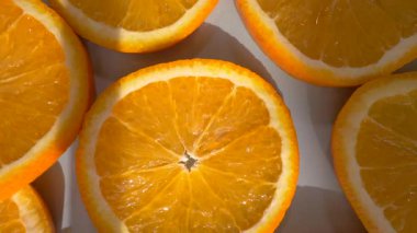 Bir tabak içinde dilimlenmiş portakal meyve halkaları, döner döner döner döner döner bir platformda. Ağır çekim. Yakın plan. Üst görünüm