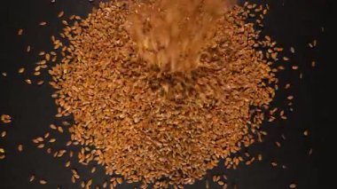 Pikapta hareket halindeki bir masaya düşen keten tohumları. Yakın plan. Üst Manzara. Yavaş çekim