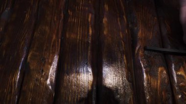 Bir ustabaşı tahta bir masayı mezurayla ölçer. Bir genel işçi inşaat mezurası ile ölçü alır. Yavaş çekim.