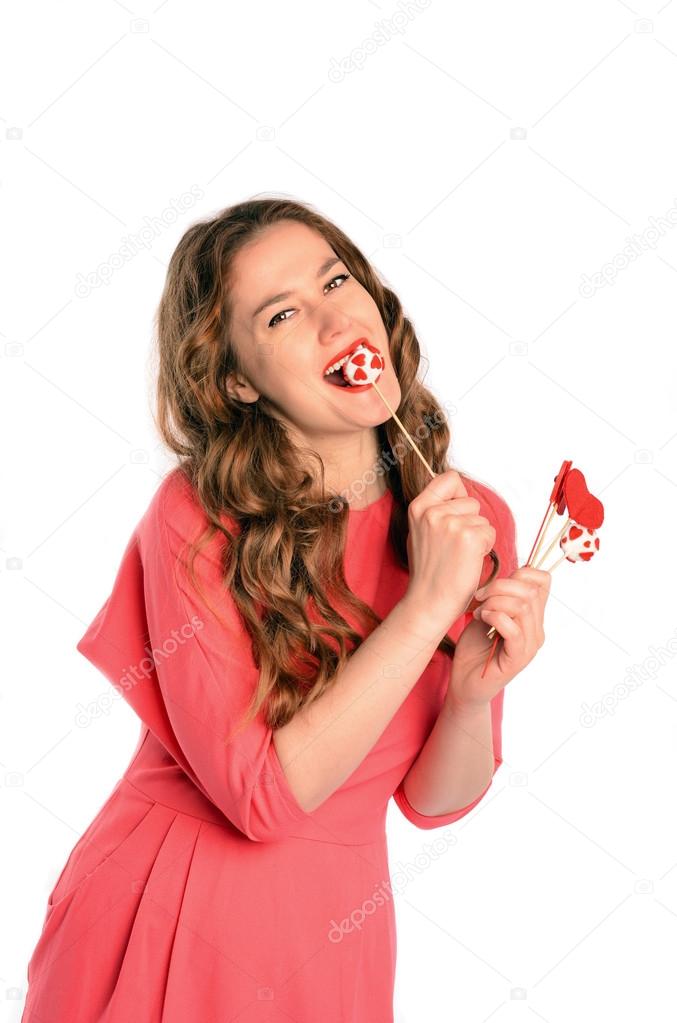 Brunette long hair young woman biting cake pop.  Isolated on white background
