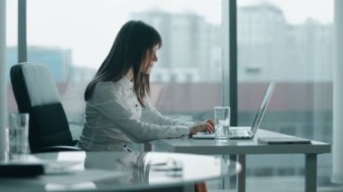 modern ofis bir dizüstü bilgisayarda çalışan genç iş kadını. o gülümseyen ve bir mola