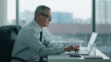 yaşlı işadamı modern ofisindeki bilgisayarla çalışma. Sırtı ağrıyor olduğunu