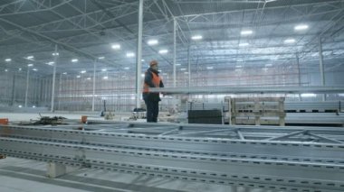 adam yeni modern sanayi ambarındaki metal konstrüksiyon taşır