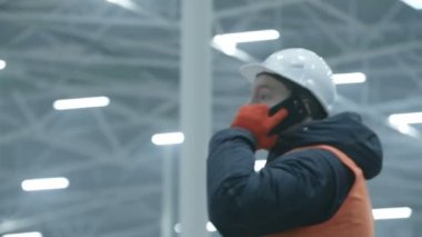 yeni modern sanayi ambarındaki telefonda konuşurken mühendisi