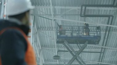 mühendis Kaynakçı üzerinde döner ve modern endüstriyel depo kameraya görünüyor bir kask içinde portresi