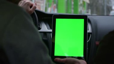 iki kişi modern Araba sürme ve tablet ile yeşil perde rotasında tartışmak