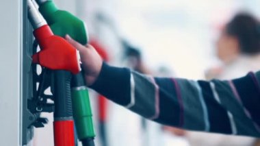 Bir benzin istasyonunda yakıt püskürtme uçlarını kullanarak Mens ele