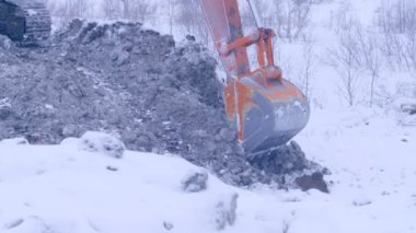 Ekskavatör kış günü kar toprağa kazma