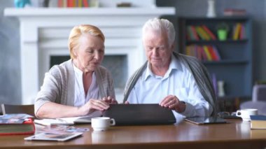 Üst düzey çift websurfing dizüstü bilgisayar ile Internet üzerinde. Mutlu yaşlı adam ve bilgisayar kullanan kadın