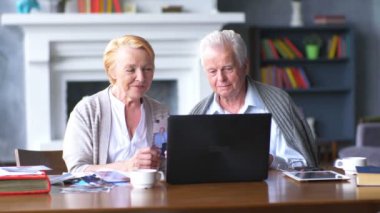 Yaşlı çift rahat oturma odasında internette aile ile iletişim içinde eğleniyor
