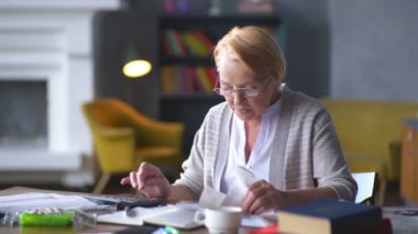 yaşlı kadın faturaları hakkında endişelenir. o Hesap makinesinde dikkate alır ve altüst olur