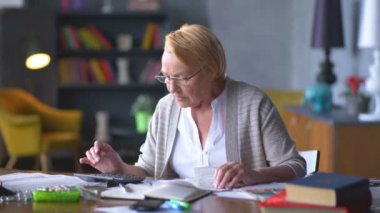 yaşlı kadın faturaları hakkında endişelenir. o Hesap makinesinde dikkate alır ve altüst olur