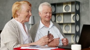 Yaşlı çift rahat oturma odasında internette aile ile iletişim içinde eğleniyor