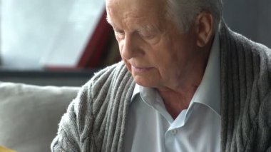 yaşlı beyaz adam modern bir dairede bir kitap okuma